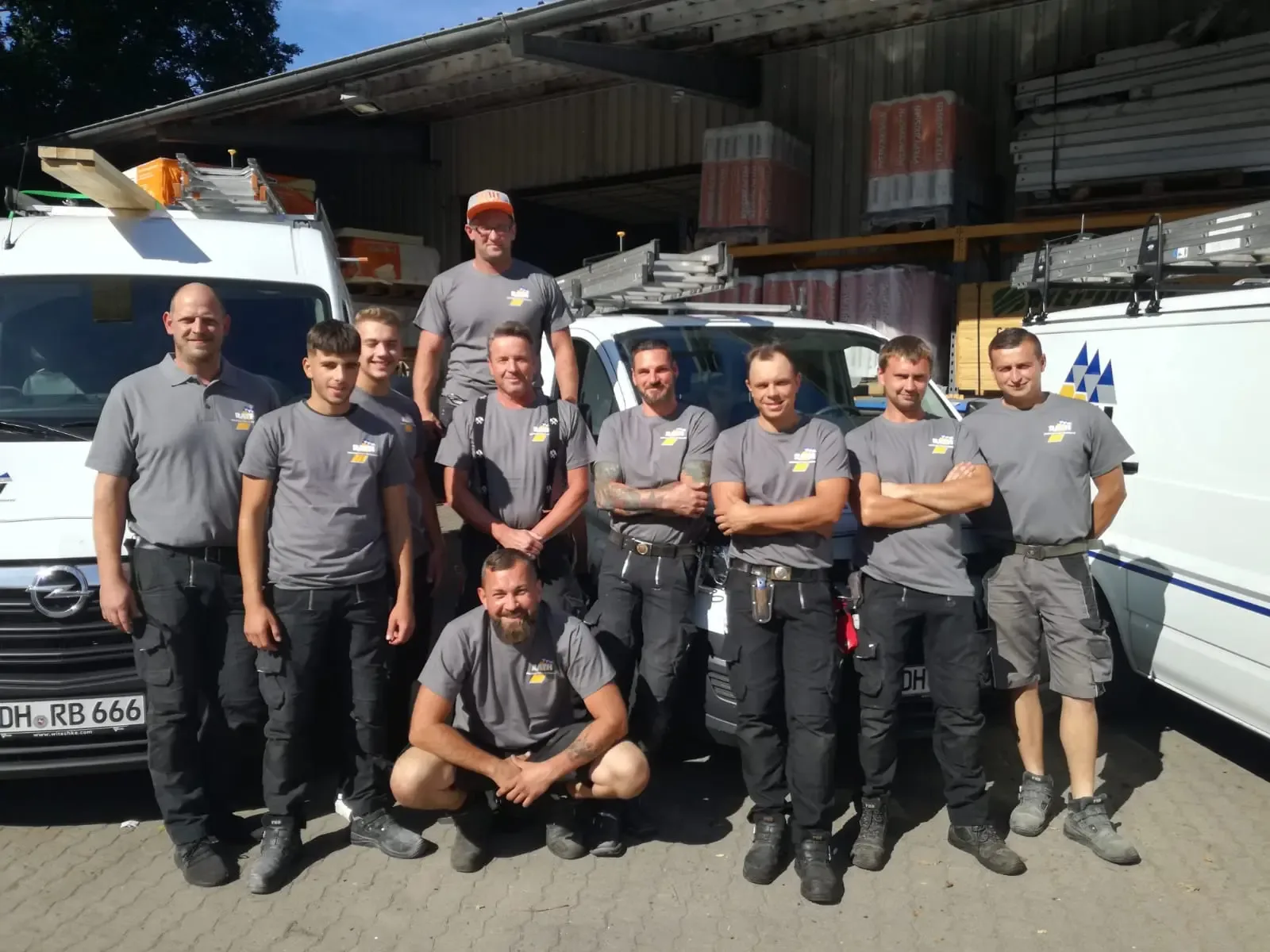 Das Team von Rath Bedachungen vor den Firmenfahrzeugen